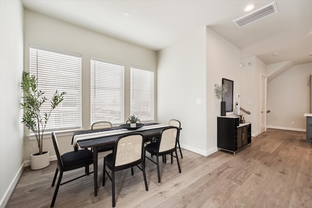 dining room with light wood-style floors, visible vents, and baseboards