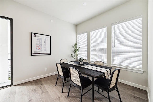 dining area with baseboards and wood finished floors