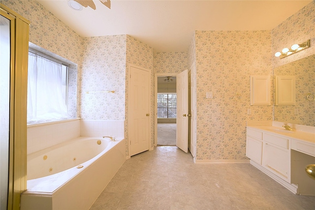 full bathroom with wallpapered walls, baseboards, vanity, and a tub with jets