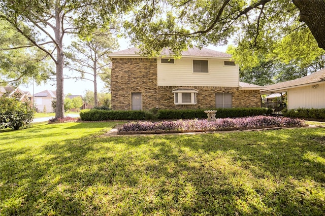 traditional-style home with a front lawn and brick siding