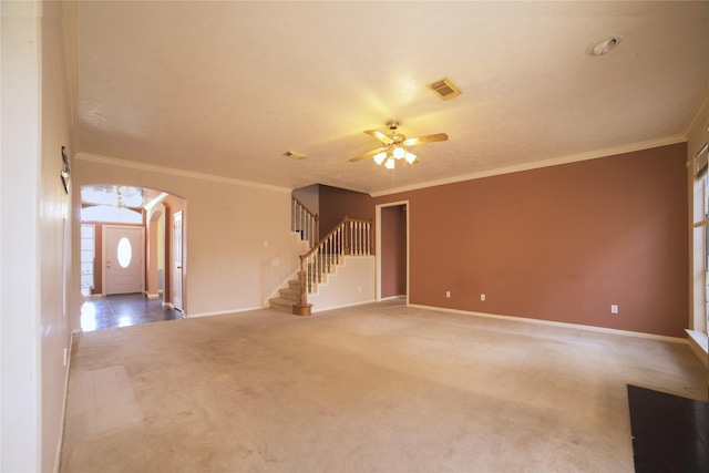 unfurnished living room with stairway, ceiling fan, arched walkways, carpet, and baseboards