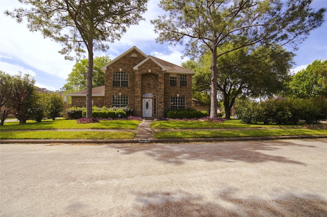 traditional-style home with a front lawn and brick siding