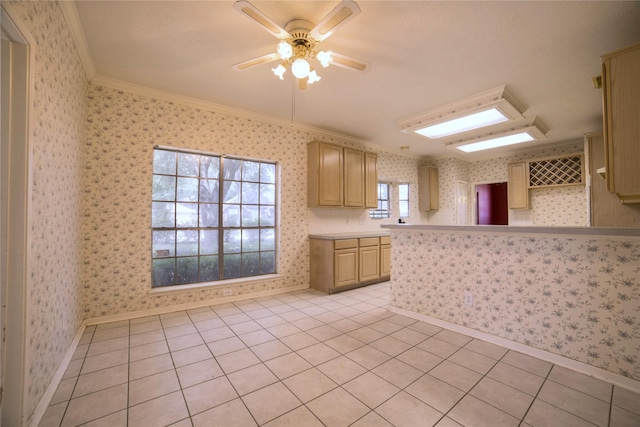 kitchen with baseboards, wallpapered walls, a ceiling fan, light countertops, and ornamental molding