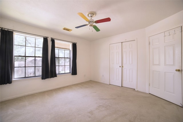 unfurnished bedroom featuring baseboards, visible vents, a closet, and light colored carpet