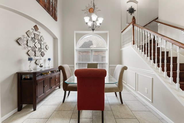 8322 Calico Canyon Dr, Tomball, TX 77375 - dining area featuring a chandelier, stairway, a wainscoted wall, a decorative wall, and a high ceiling