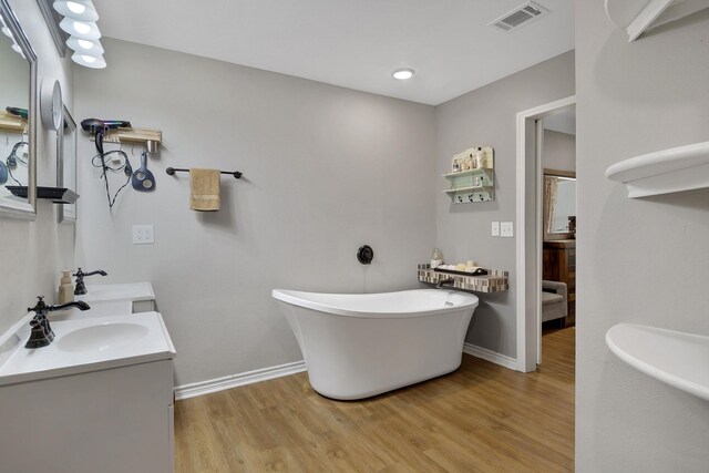 310 Hidden Oaks Dr, Point Blank, TX 77364 - bathroom with a freestanding tub, wood finished floors, a sink, and visible vents