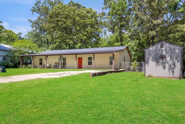 310 Hidden Oaks Dr, Point Blank, TX 77364 - ranch-style home with fence, a shed, stucco siding, an outdoor structure, and a front yard