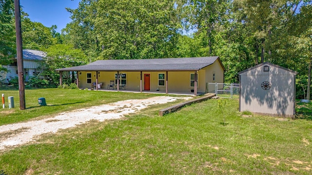 310 Hidden Oaks Dr, Point Blank, TX 77364 - view of front of house featuring a storage shed, an outbuilding, a front yard, and fence