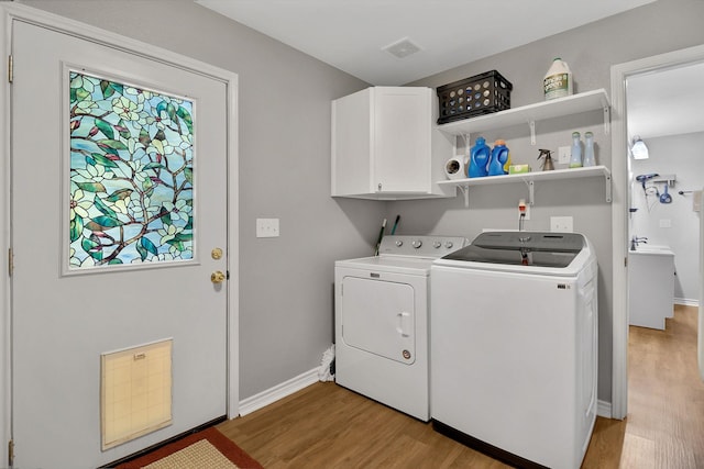 310 Hidden Oaks Dr, Point Blank, TX 77364 - laundry area with washer and dryer, cabinet space, visible vents, and light wood-type flooring
