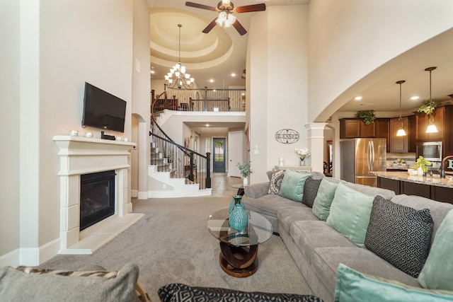 3225 Summer Tanager Ln, Manvel, TX 77578 - living room with ceiling fan, arched walkways, a glass covered fireplace, a high ceiling, and stairway