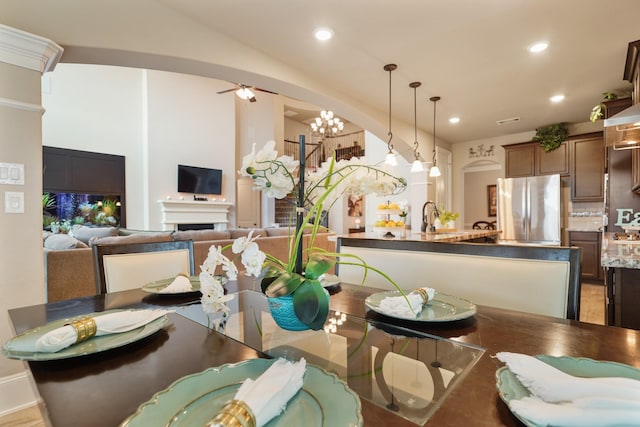 3225 Summer Tanager Ln, Manvel, TX 77578 - dining area featuring arched walkways, recessed lighting, a chandelier, ceiling fan, and a fireplace