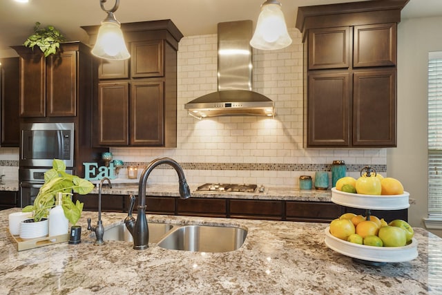 3225 Summer Tanager Ln, Manvel, TX 77578 - kitchen featuring wall chimney range hood, appliances with stainless steel finishes, a sink, decorative backsplash, and light stone counters