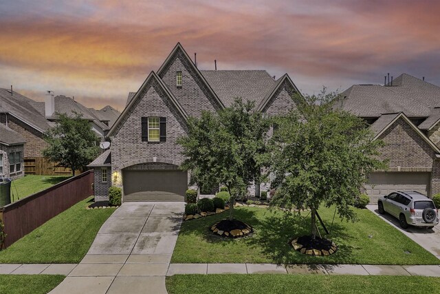 3225 Summer Tanager Ln, Manvel, TX 77578 - french country home featuring brick siding, an attached garage, driveway, and a front lawn