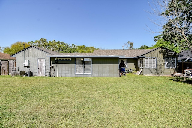 1905 Tennessee St, Baytown, TX 77520 - back of house with fence, a lawn, and roof with shingles