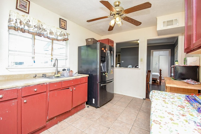 1905 Tennessee St, Baytown, TX 77520 - kitchen featuring visible vents, light countertops, a sink, stainless steel fridge, and red cabinetry