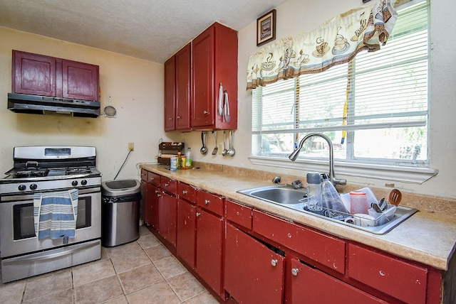 1905 Tennessee St, Baytown, TX 77520 - kitchen featuring a healthy amount of sunlight, gas range, red cabinetry, and under cabinet range hood