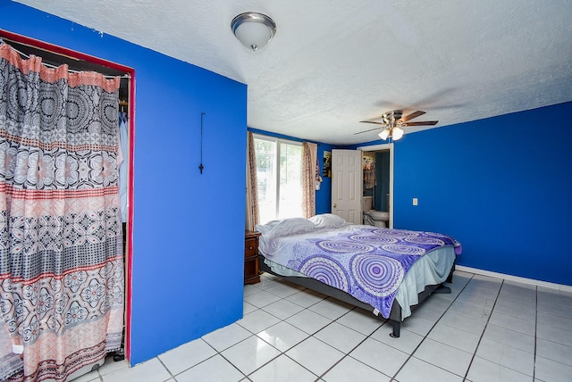 1905 Tennessee St, Baytown, TX 77520 - bedroom with a textured ceiling, baseboards, and light tile patterned flooring