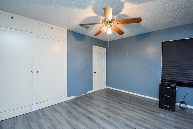 1905 Tennessee St, Baytown, TX 77520 - unfurnished bedroom featuring ceiling fan, baseboards, a textured ceiling, and wood finished floors