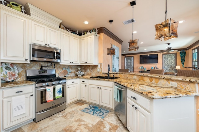 206 China Clipper Dr, Freeport, TX 77541 - kitchen with visible vents, a sink, appliances with stainless steel finishes, a peninsula, and decorative backsplash