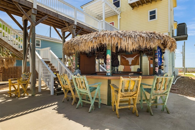 206 China Clipper Dr, Freeport, TX 77541 - view of patio featuring central air condition unit, outdoor dry bar, and stairs