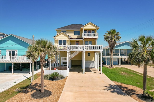 206 China Clipper Dr, Freeport, TX 77541 - beach home featuring a carport, stairs, a balcony, and concrete driveway