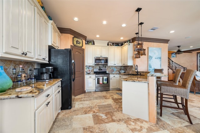 206 China Clipper Dr, Freeport, TX 77541 - kitchen featuring tasteful backsplash, a peninsula, a breakfast bar, a sink, and stainless steel appliances
