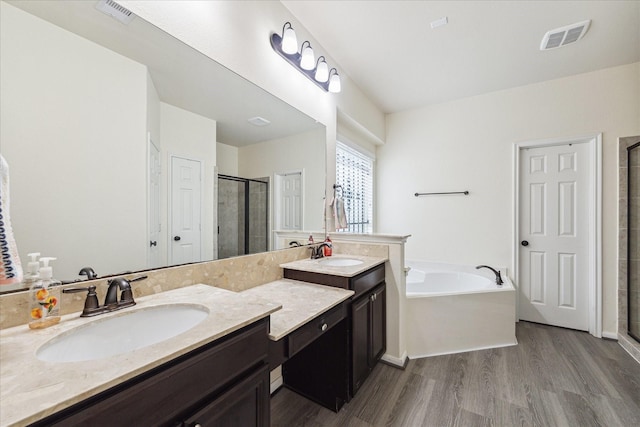 full bathroom with wood finished floors, visible vents, a shower stall, and a garden tub