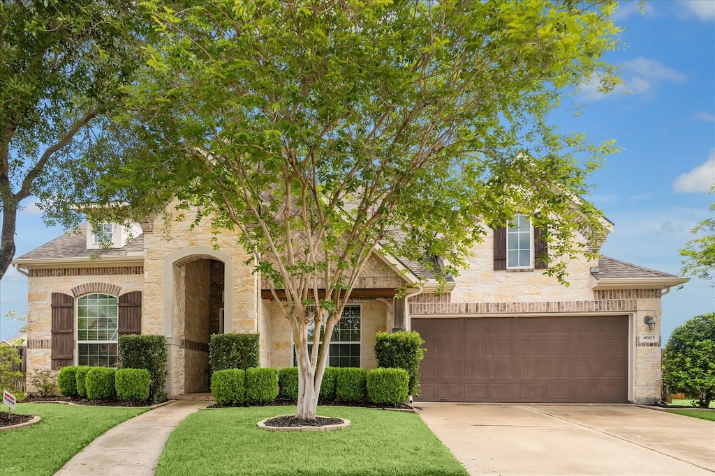 4603 Monarch Bluff Ct, Sugar Land, TX 77479 - view of front of home with stone siding, driveway, a front yard, and a garage
