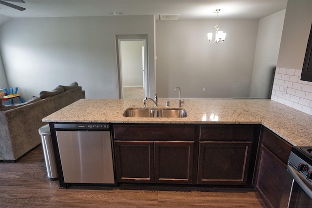 kitchen featuring dark brown cabinetry, light stone counters, visible vents, stainless steel appliances, and a sink