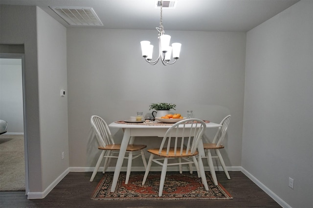 dining area with baseboards, wood finished floors, a notable chandelier, and visible vents