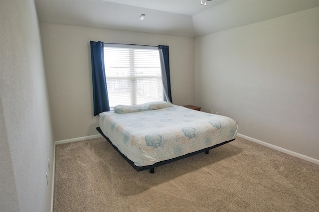 carpeted bedroom with baseboards and lofted ceiling