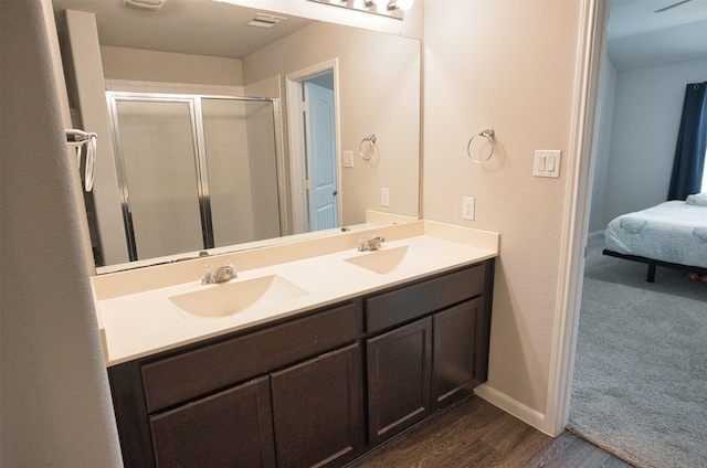 bathroom with a sink, visible vents, a shower stall, and double vanity