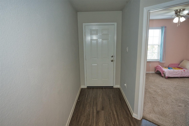 doorway to outside with dark wood-style flooring, baseboards, and a ceiling fan