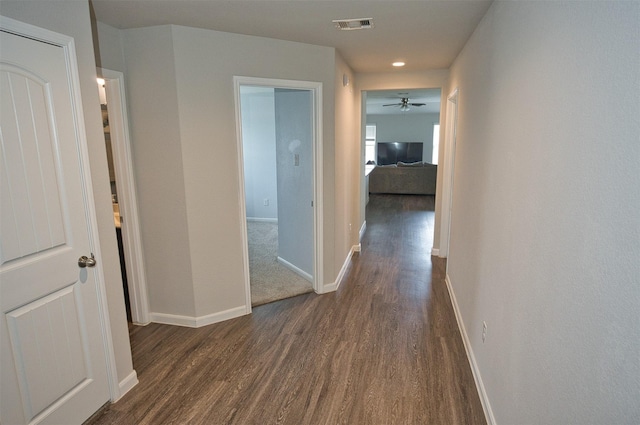 hall featuring baseboards, dark wood finished floors, visible vents, and recessed lighting