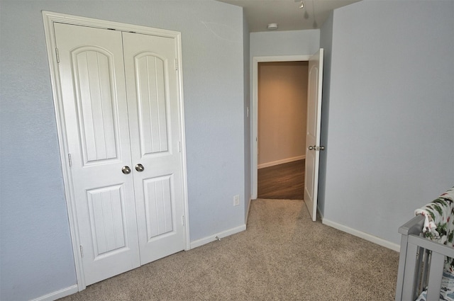 unfurnished bedroom featuring carpet floors, baseboards, and a closet