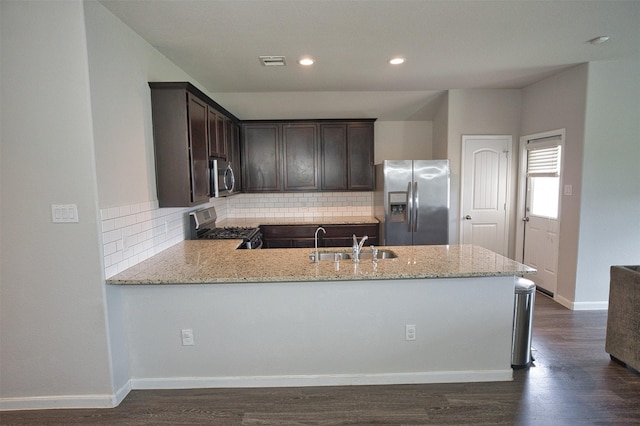 kitchen featuring light stone counters, dark brown cabinets, visible vents, decorative backsplash, and stainless steel appliances