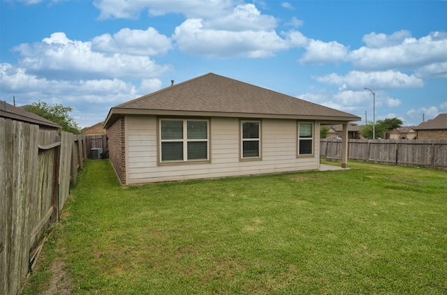 back of house featuring a yard, a fenced backyard, cooling unit, and roof with shingles