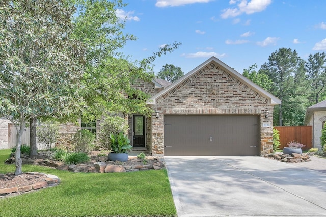 114 Winecup Cir, Montgomery, TX 77316 - view of front of house featuring a garage, fence, stone siding, brick siding, and concrete driveway