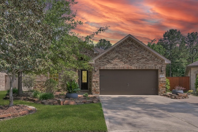 114 Winecup Cir, Montgomery, TX 77316 - view of front facade featuring stone siding, concrete driveway, brick siding, an attached garage, and a yard
