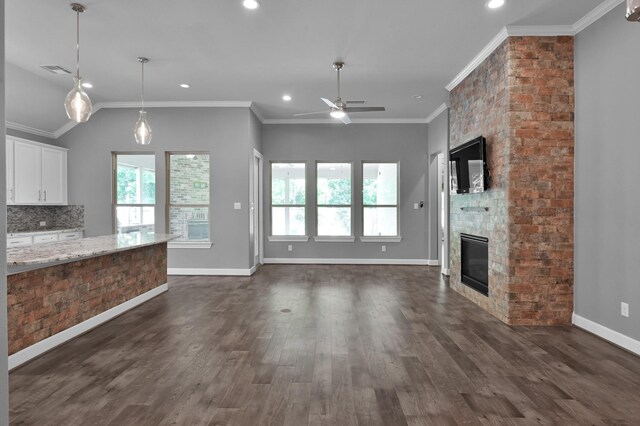 114 Winecup Cir, Montgomery, TX 77316 - unfurnished living room featuring a large fireplace, visible vents, ceiling fan, and plenty of natural light
