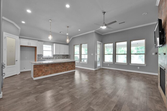 114 Winecup Cir, Montgomery, TX 77316 - kitchen with a fireplace, tasteful backsplash, visible vents, open floor plan, and baseboards