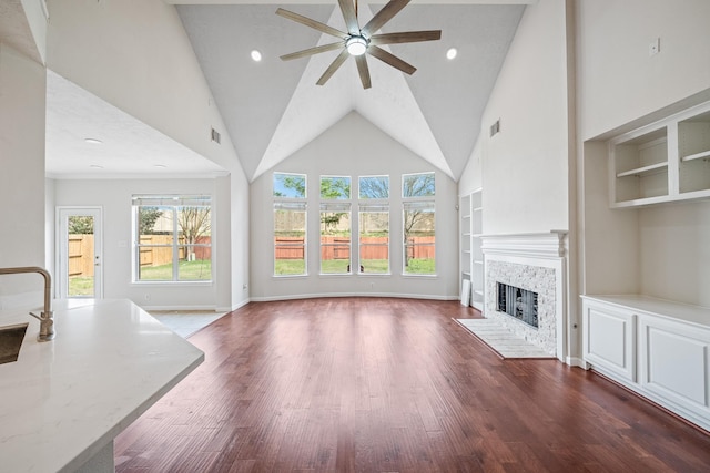 6214 Laguna Del Rey Dr, Houston, TX 77041 - unfurnished living room with a fireplace, a ceiling fan, dark wood-type flooring, visible vents, and built in shelves