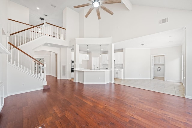 6214 Laguna Del Rey Dr, Houston, TX 77041 - unfurnished living room with visible vents, arched walkways, ceiling fan, light wood-style floors, and stairway