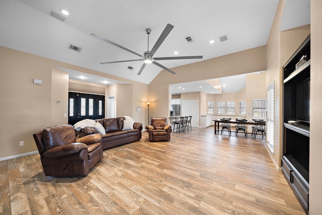 living room with visible vents, light wood-style flooring, ceiling fan, and lofted ceiling