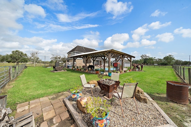 view of yard featuring a gazebo, a fire pit, a fenced backyard, and a patio area
