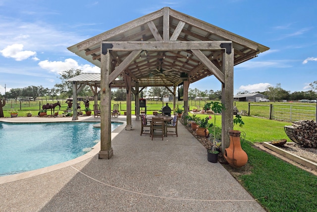 outdoor pool with a gazebo, a patio, a yard, and fence