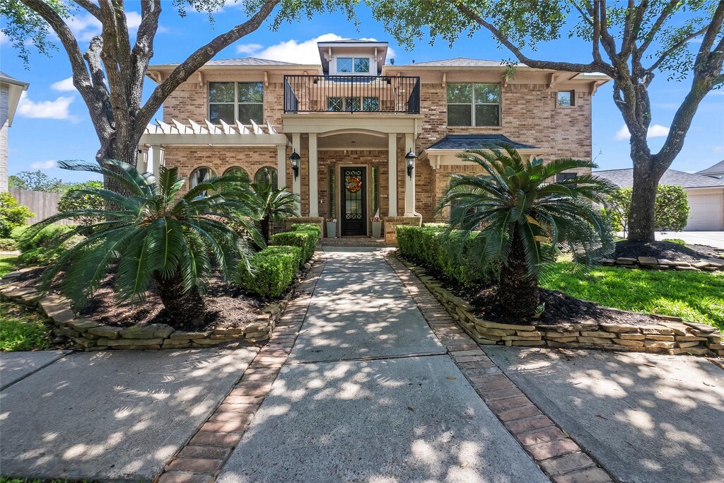 14002 Hunters Lake Ct, Houston, TX 77044 - mediterranean / spanish-style house featuring brick siding, fence, and a balcony