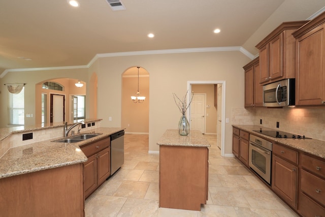 kitchen with a center island, visible vents, decorative backsplash, stainless steel appliances, and a sink