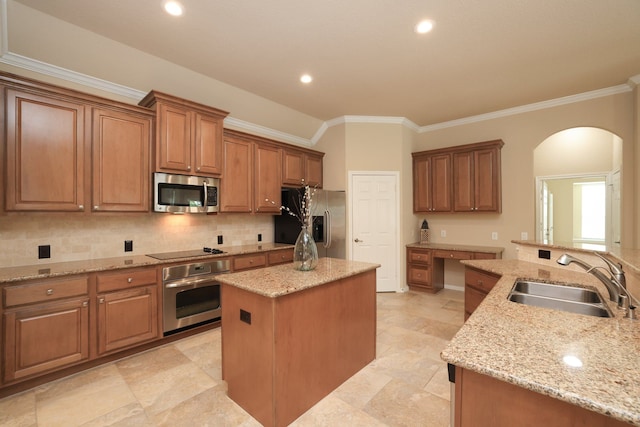 kitchen with a center island, a sink, appliances with stainless steel finishes, crown molding, and decorative backsplash