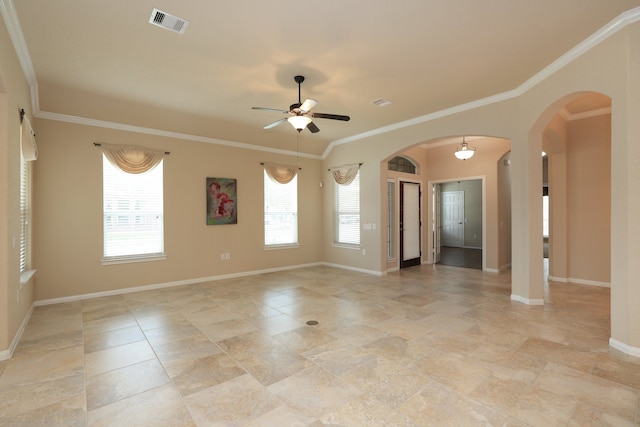 spare room featuring arched walkways, visible vents, ornamental molding, and plenty of natural light